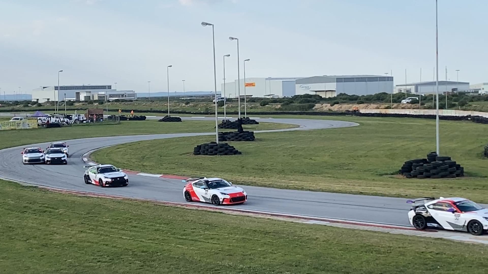 Circuit race cars taking a sweeping corner during a South African track session
